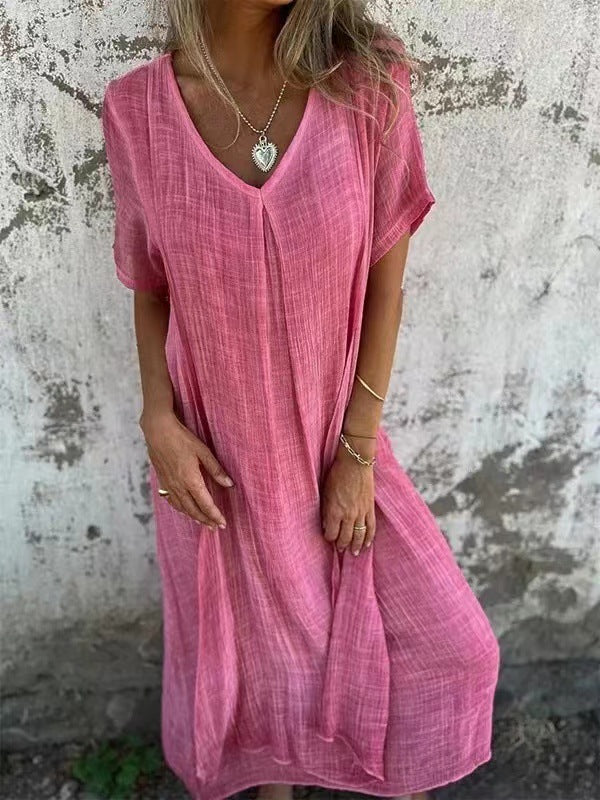Model in a lightweight short sleeve dress against a cement background.