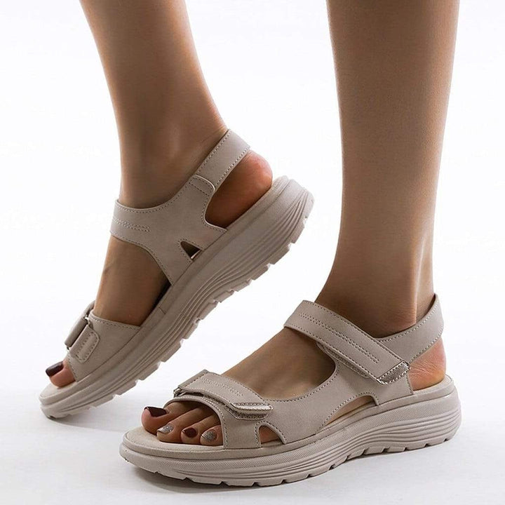 Woman wearing casual comfort sandals with cushioned soles on a plain background.