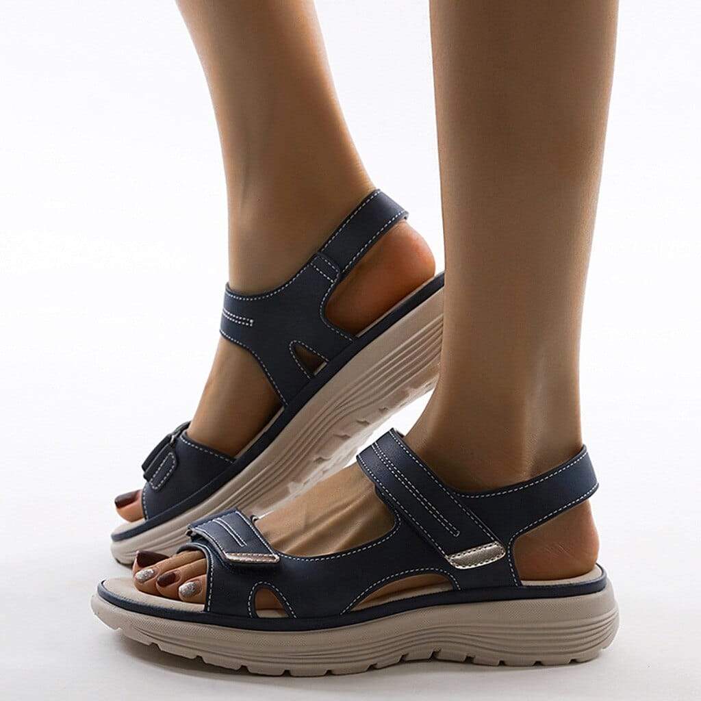 Female model showcasing lightweight walking sandals with adjustable straps on a plain background.